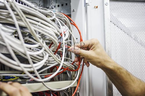 技术人员在网络服务器机房,互联网技术硬件中切换数据光缆图片素材下